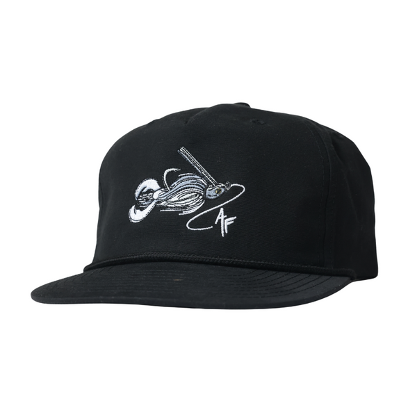 A black flat-brim baseball cap featuring a white embroidered graphic of a baseball player sliding in front of a bat on the front panel.