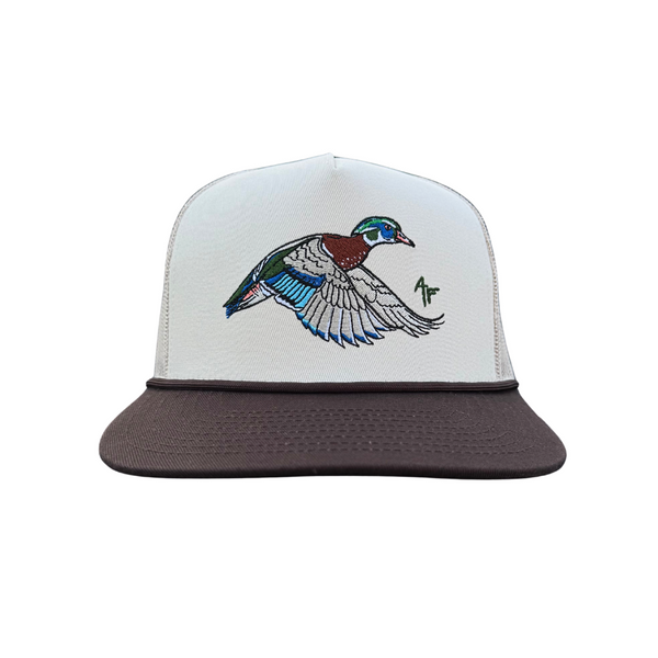 A white and dark brown trucker-style cap featuring an embroidered flying wood duck on the front panel.