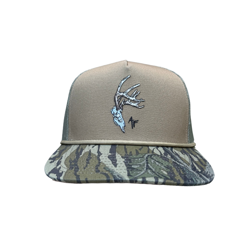 A baseball cap with a tan front panel and a camouflage-patterned visor, featuring an embroidered deer head with antlers and a small black 'AF' logo on the front.