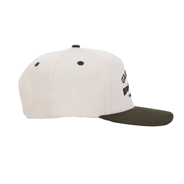 Cream Brown Bill hat that says "granda's raised on tradition" with a smoke pole design resembling hand me down.